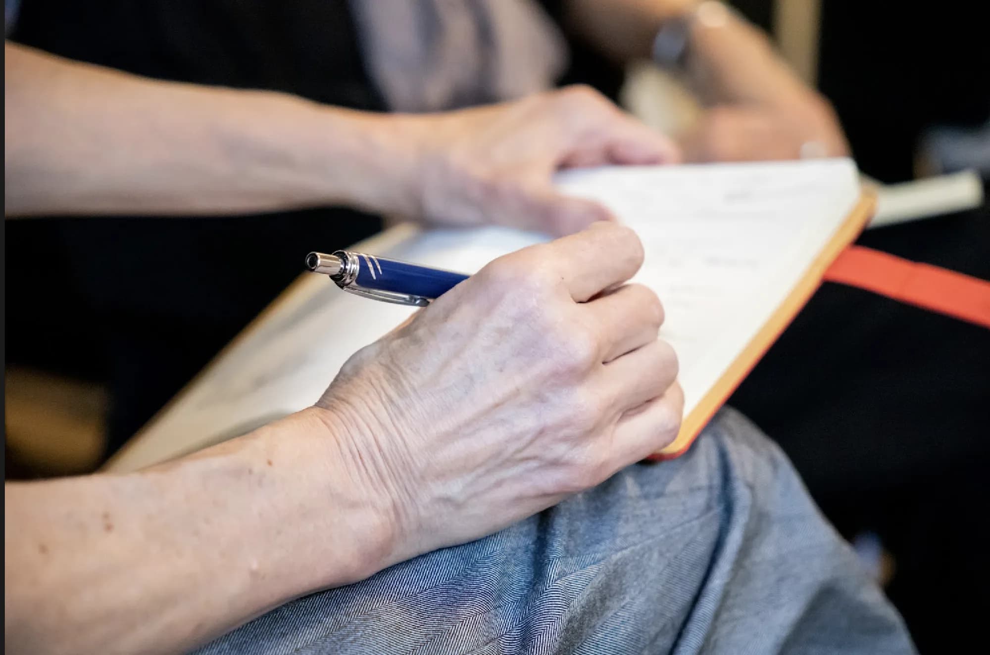 A participant taking notes in a notebook during a Lab session